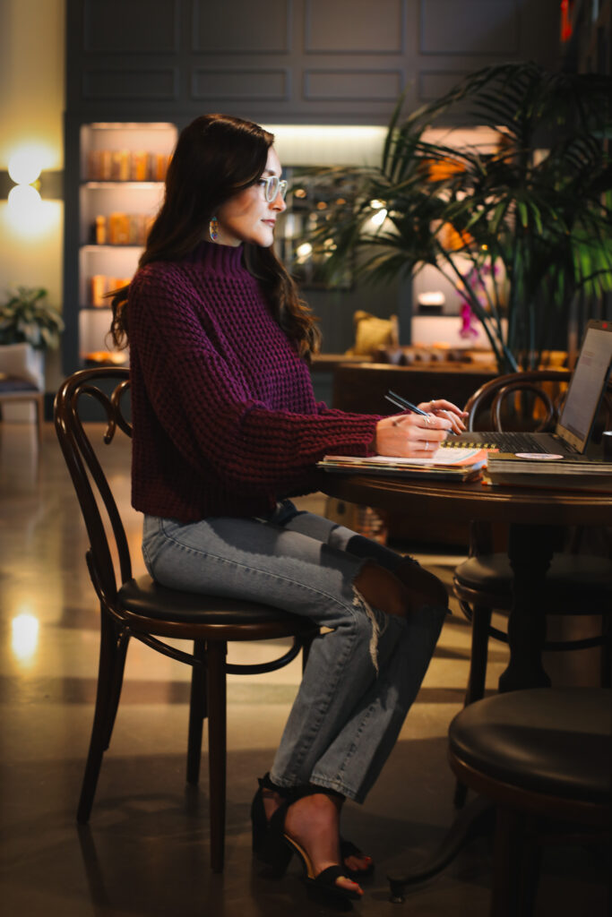 CEO of Copyrite Jane sitting at a table with her laptop in a coffee shop